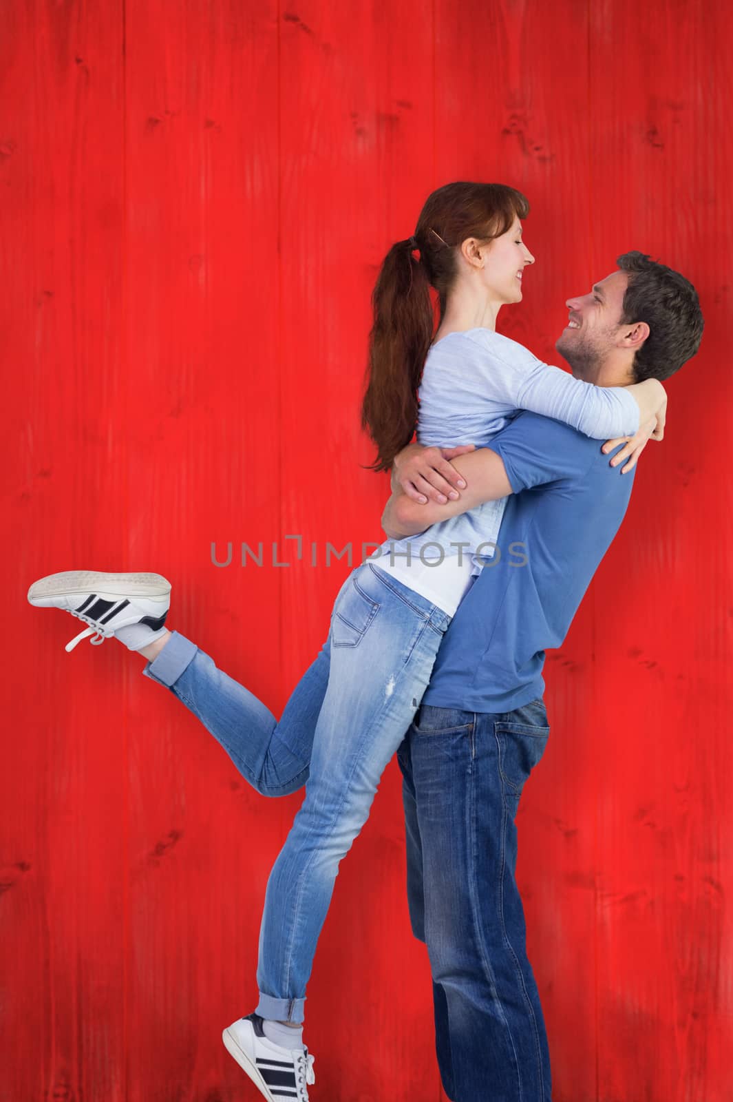 Couple hugging each other against red wooden planks