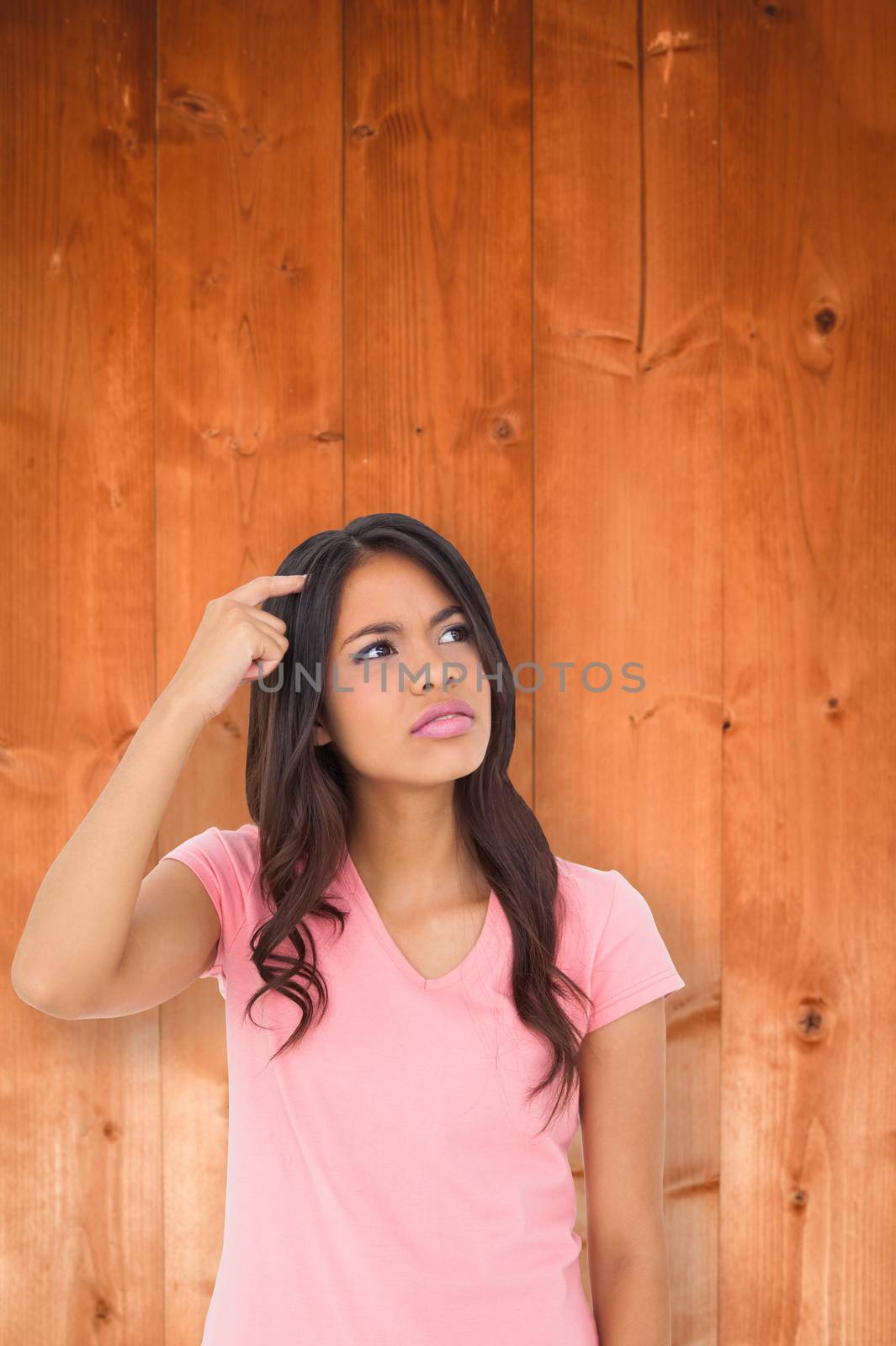Pretty brunette thinking against overhead of wooden planks