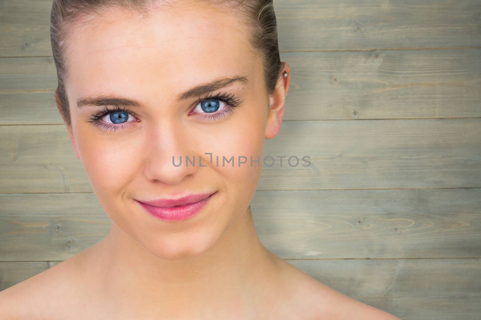 Smiling blonde natural beauty against bleached wooden planks background