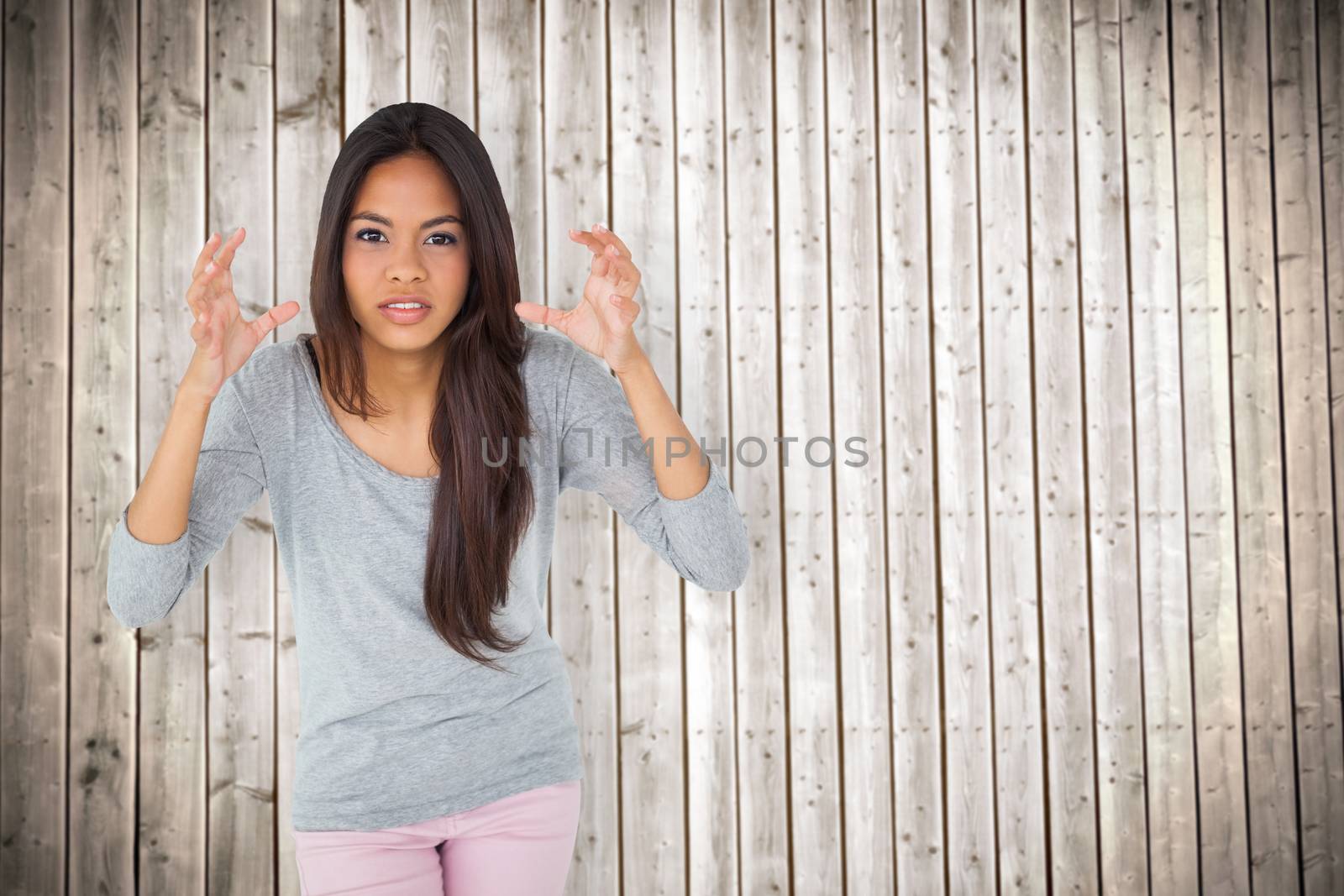 Angry brunette gesturing against wooden planks background