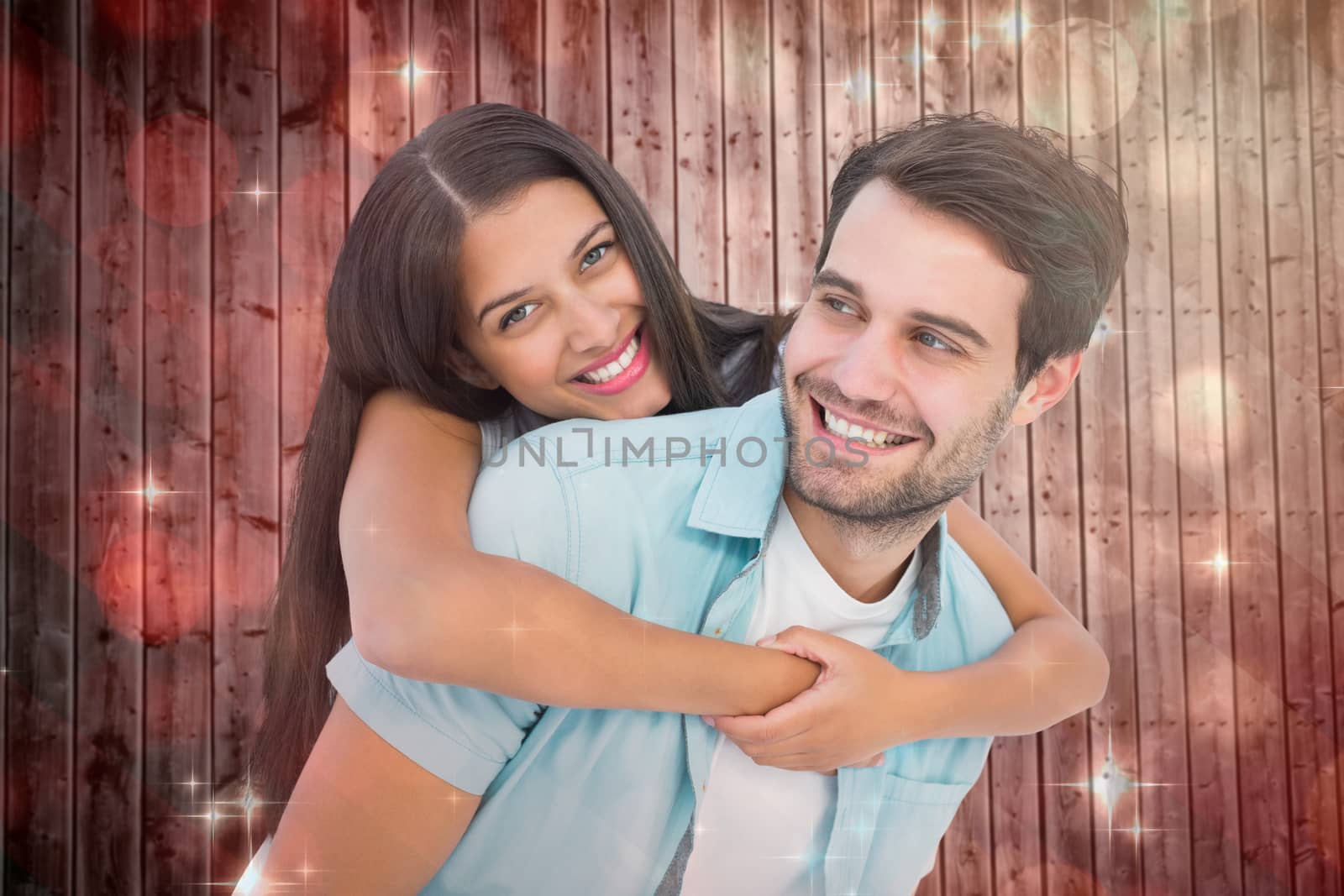 Happy casual man giving pretty girlfriend piggy back against light design shimmering on red