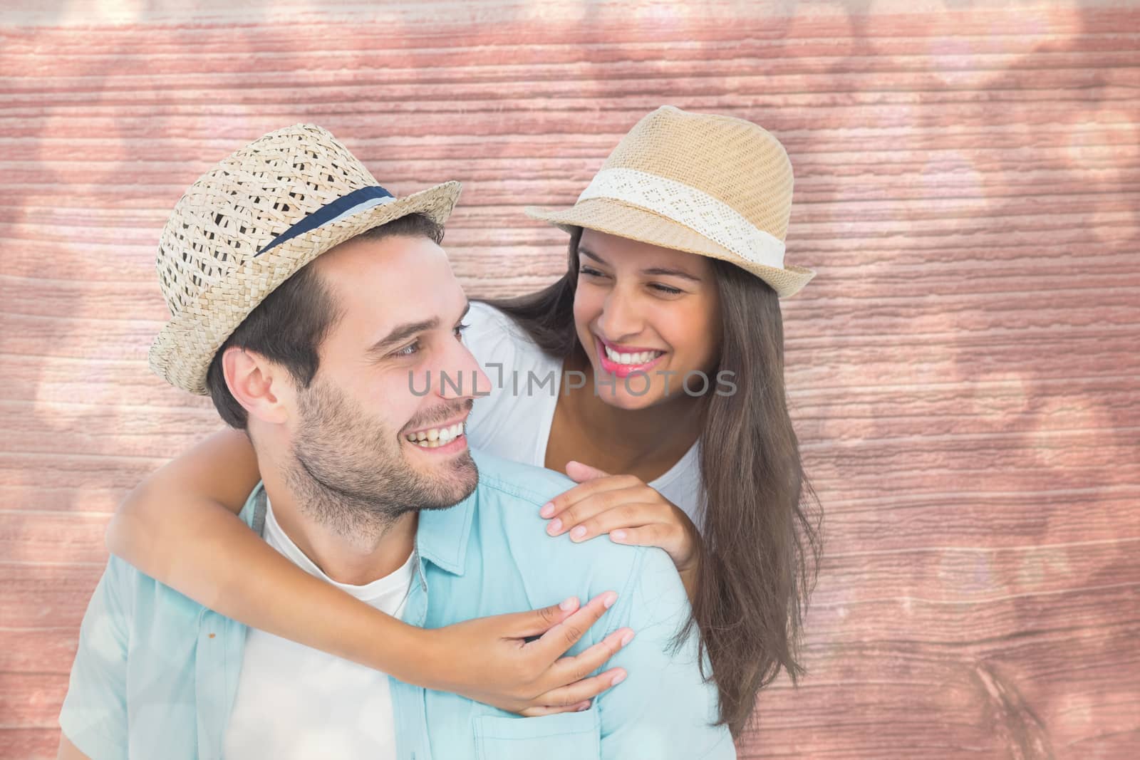 Happy casual man giving pretty girlfriend piggy back against light glowing dots design pattern