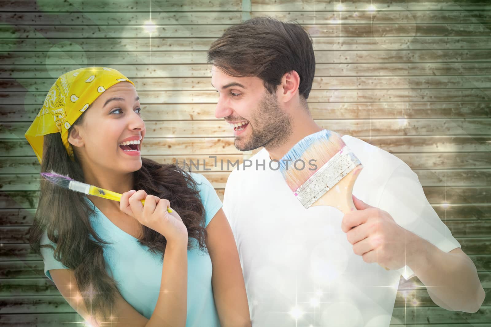 Composite image of happy young couple painting together and laughing by Wavebreakmedia