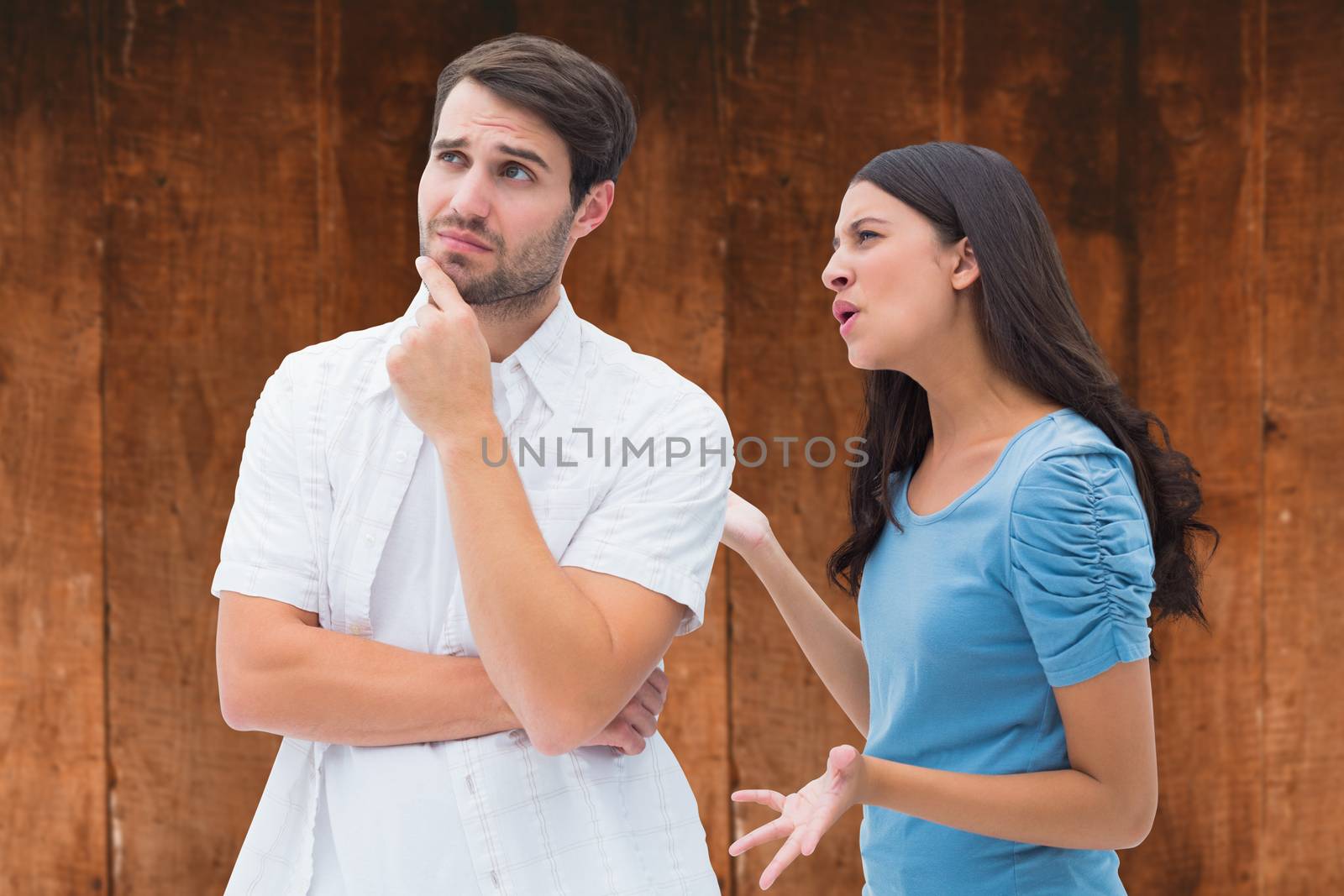 Angry brunette shouting at boyfriend against weathered oak floor boards background