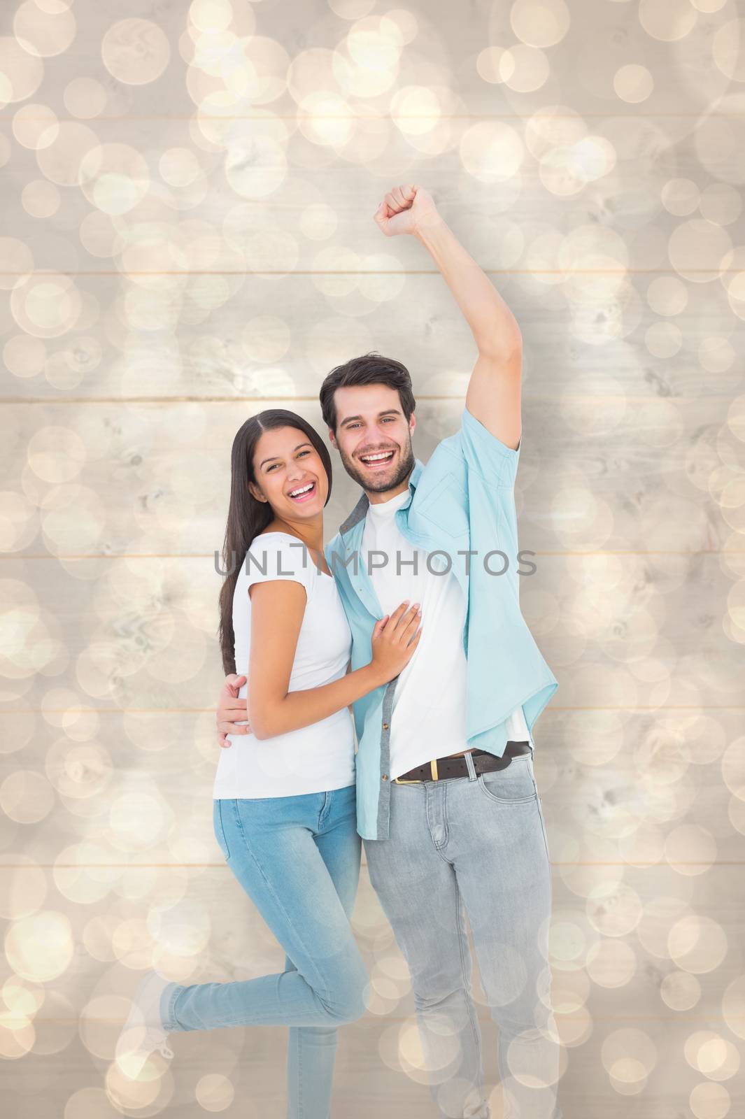 Happy casual couple cheering at camera against light glowing dots design pattern