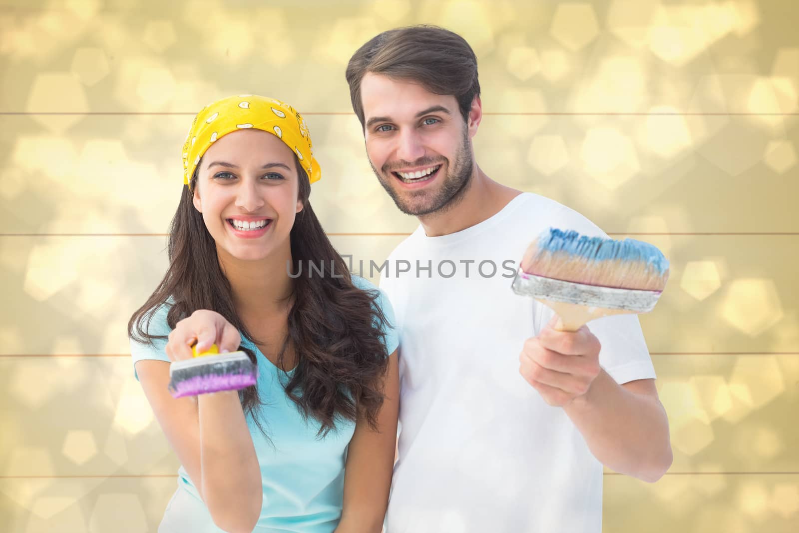 Happy young couple painting together against light glowing dots design pattern