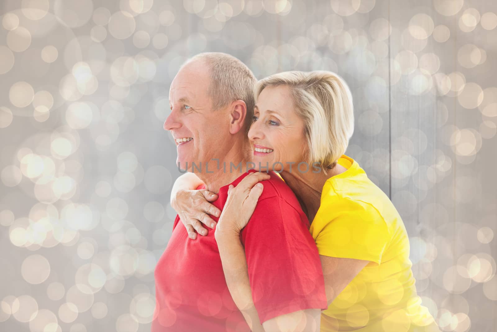 Composite image of happy mature couple hugging and smiling by Wavebreakmedia