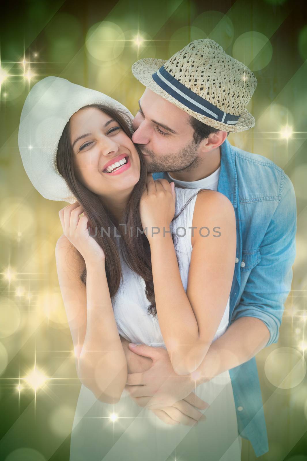 Happy hipster couple hugging and smiling against light design shimmering on green