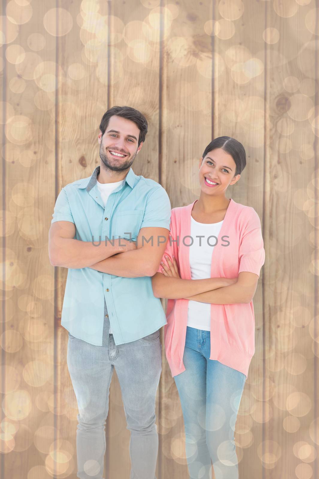 Happy couple with arms crossed against light glowing dots design pattern