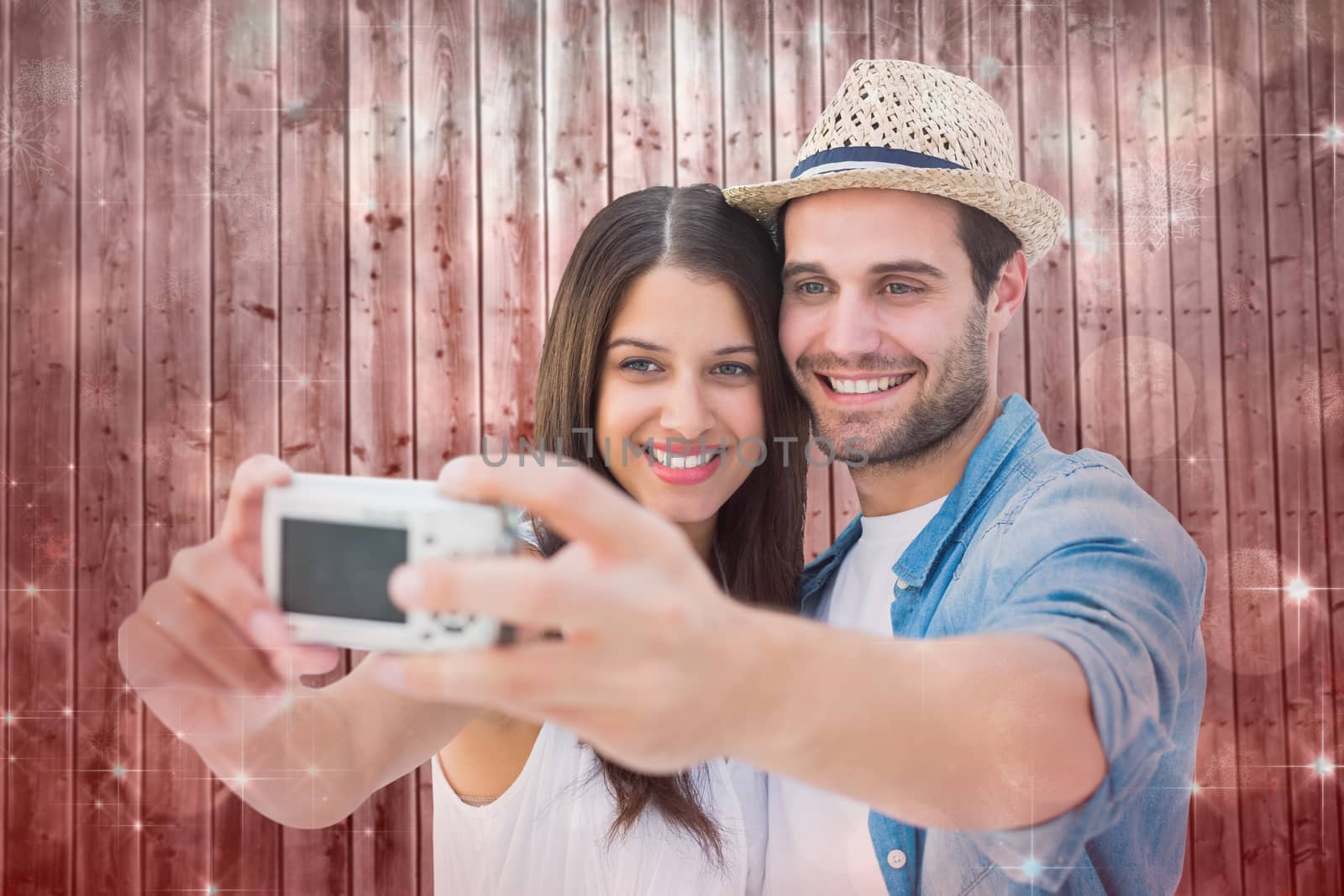 Happy hipster couple taking a selfie against shimmering light design on red