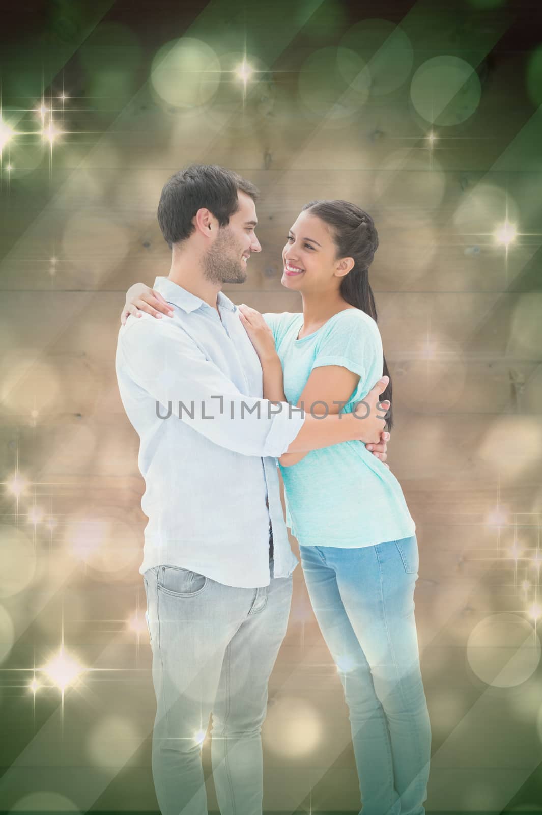 Attractive young couple hugging each other against light design shimmering on green