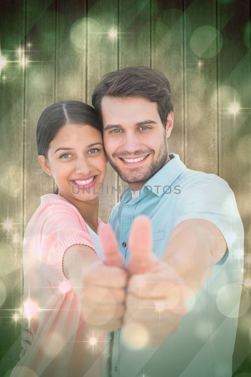 Happy couple showing thumbs up against light design shimmering on green