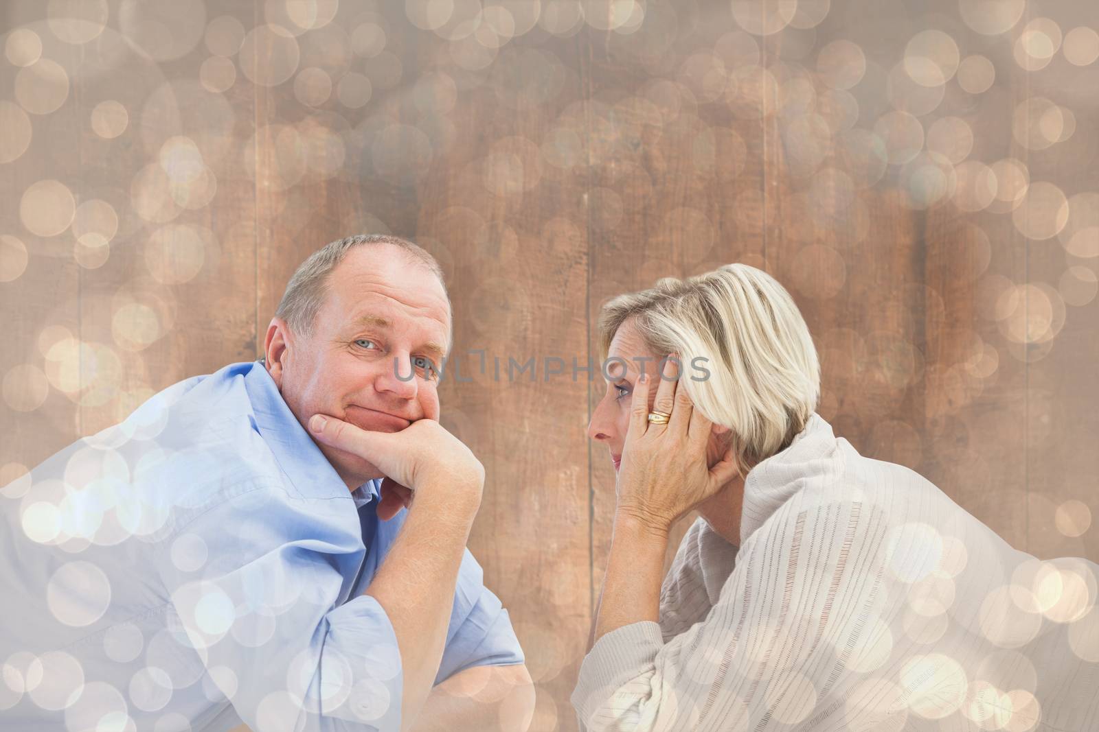 Mature couple lying and smiling against light glowing dots design pattern