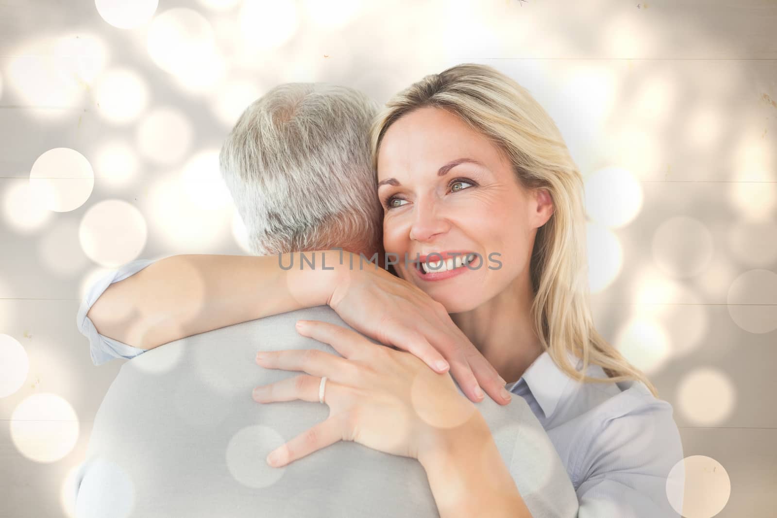 Composite image of happy couple standing and hugging by Wavebreakmedia