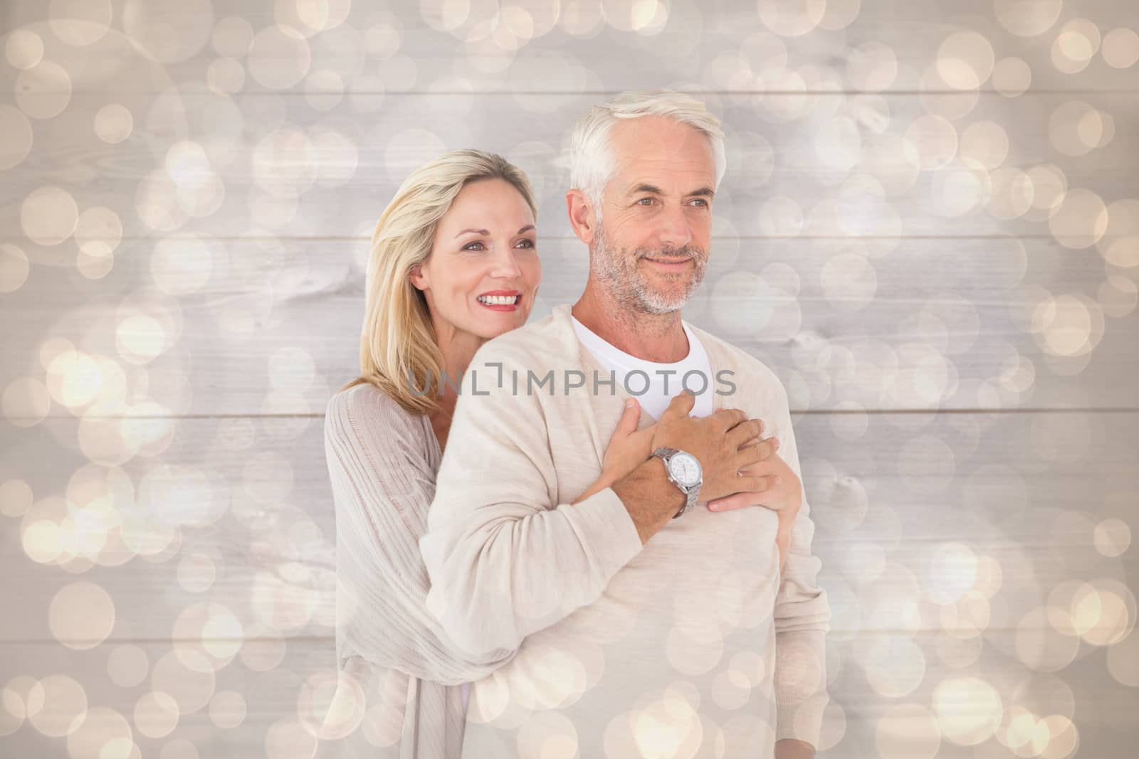 Happy couple standing and hugging against light glowing dots design pattern