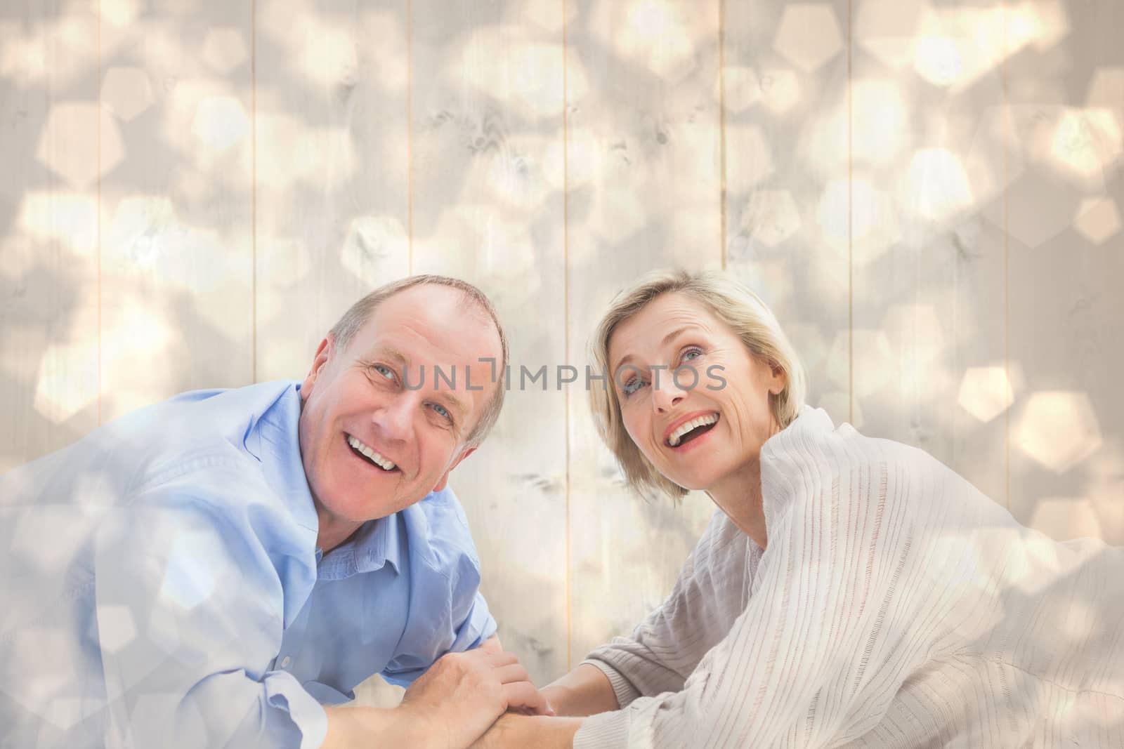 Composite image of mature couple lying and smiling by Wavebreakmedia