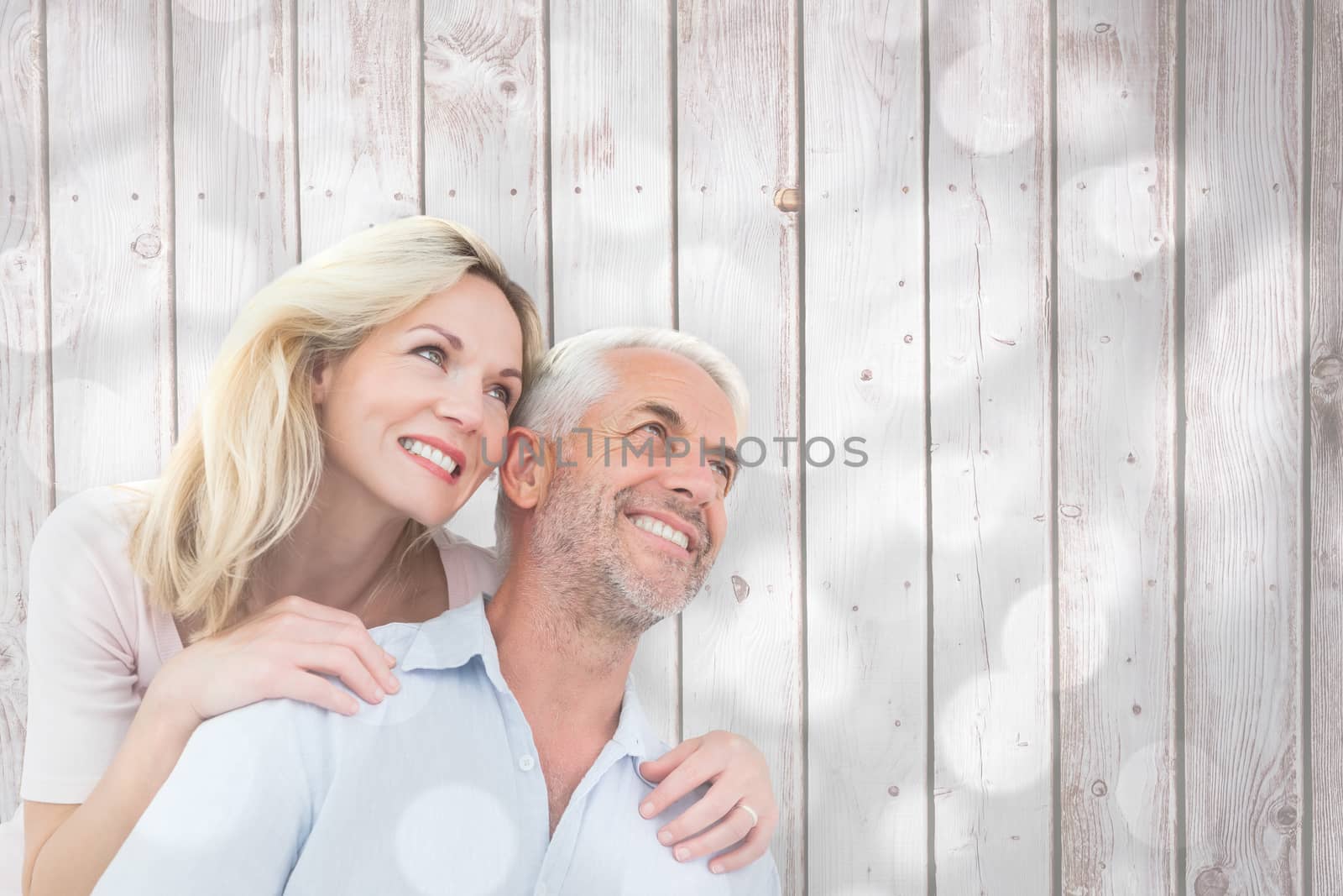 Composite image of smiling couple embracing and looking  by Wavebreakmedia
