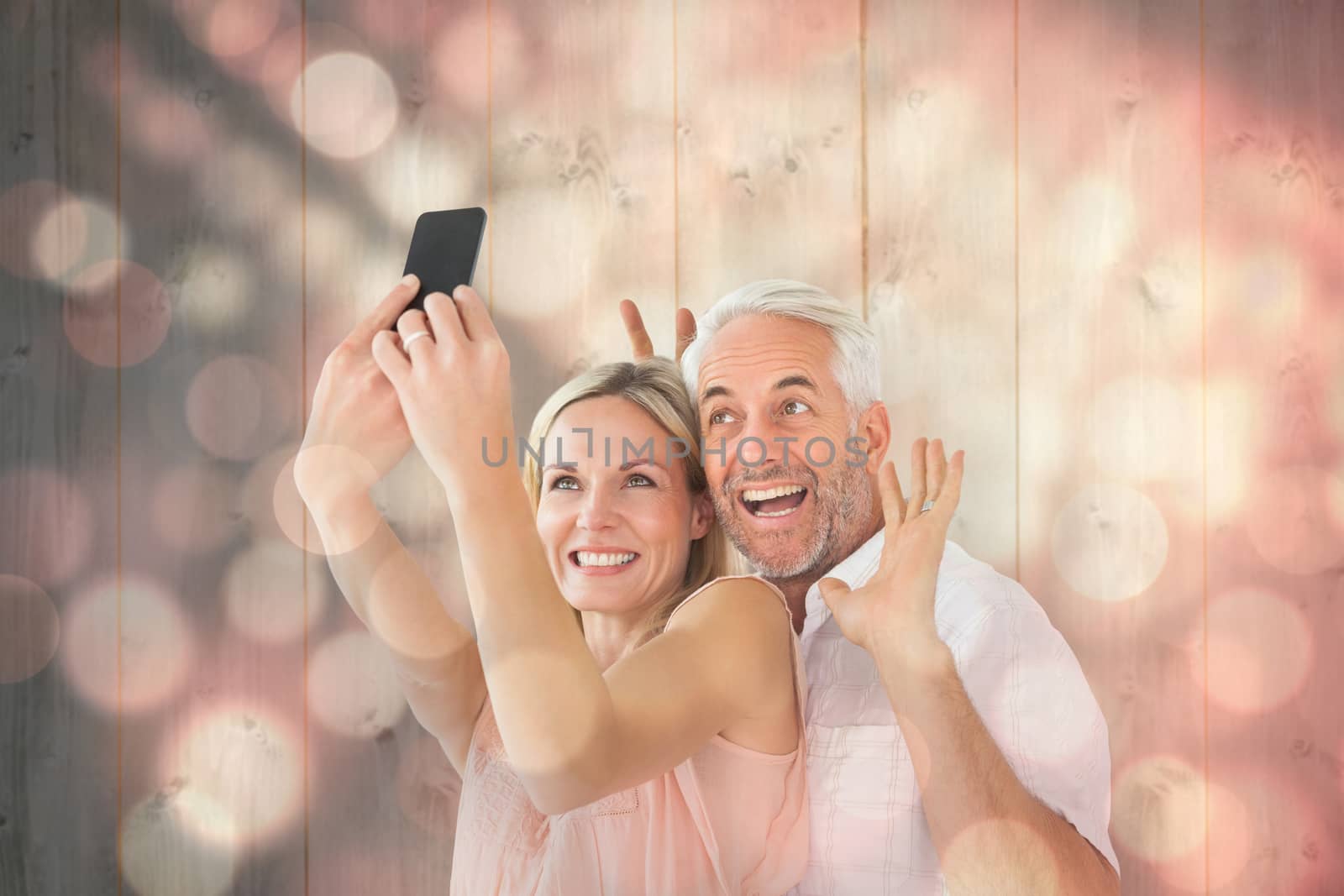 Happy couple posing for a selfie against light circles on black background
