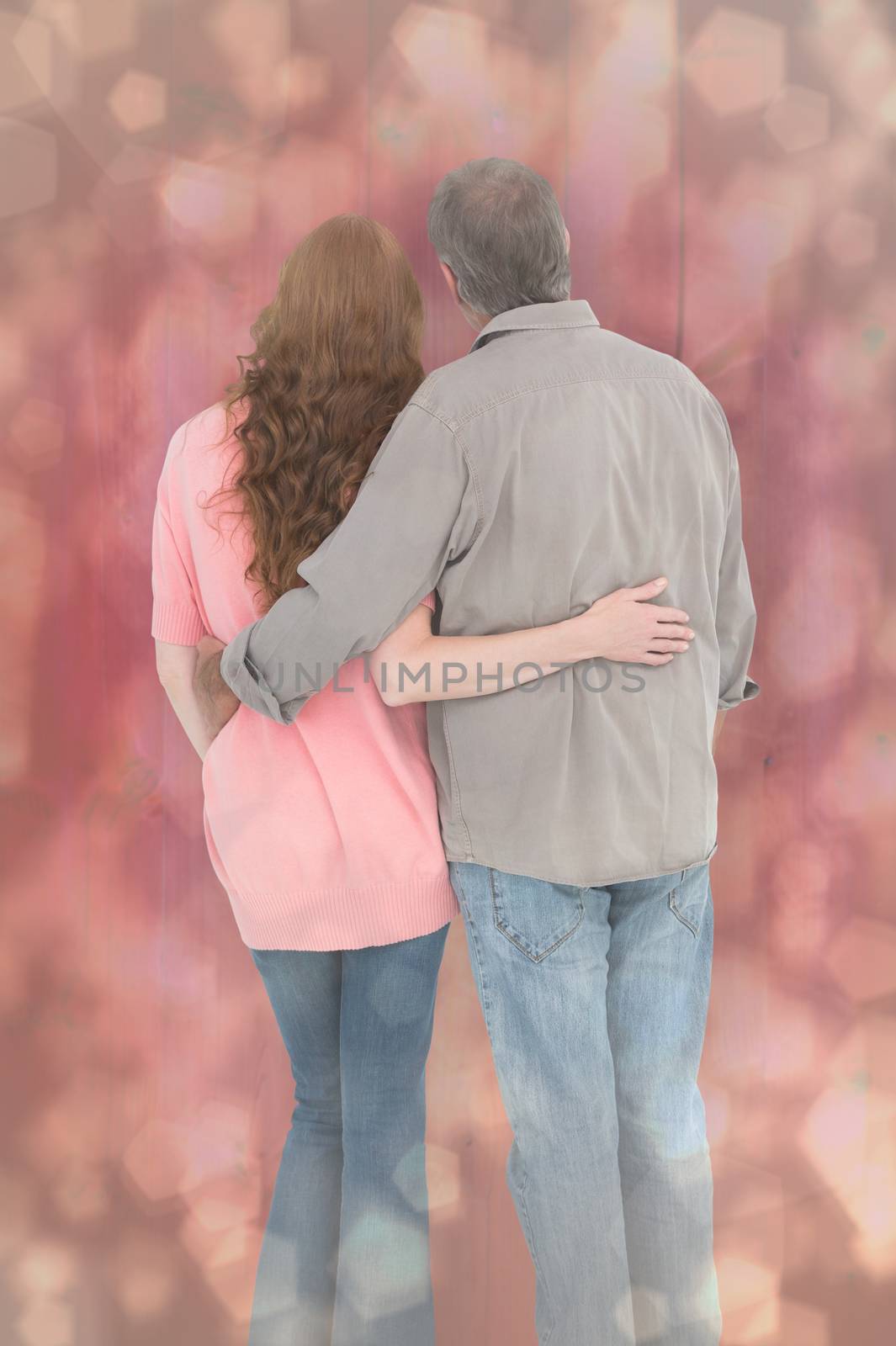 Composite image of casual couple standing arms around by Wavebreakmedia