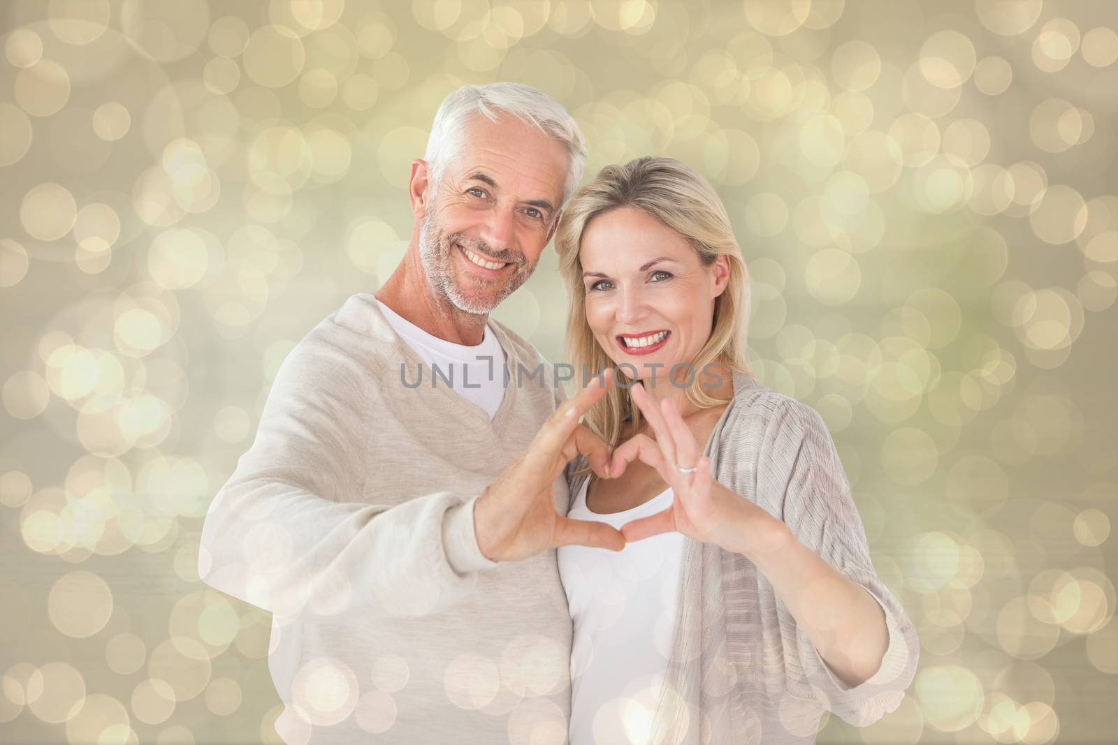 Composite image of happy couple forming heart shape with hands by Wavebreakmedia