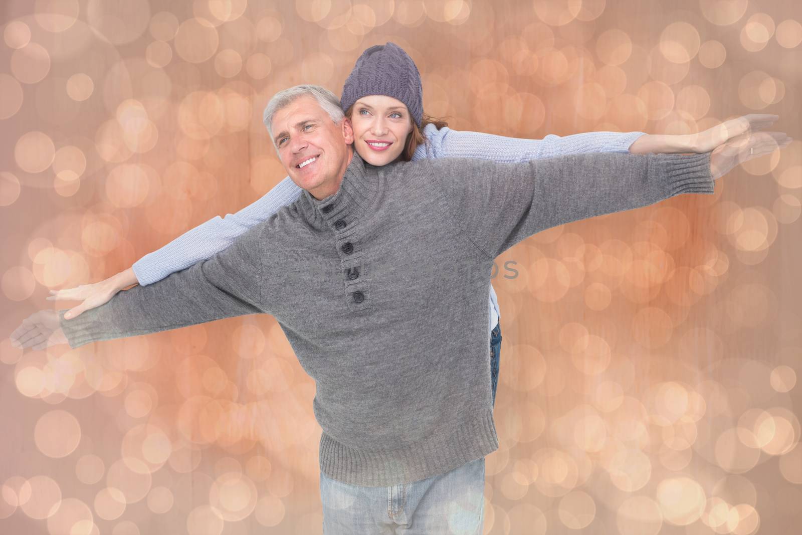 Carefree couple in warm clothing against light glowing dots design pattern