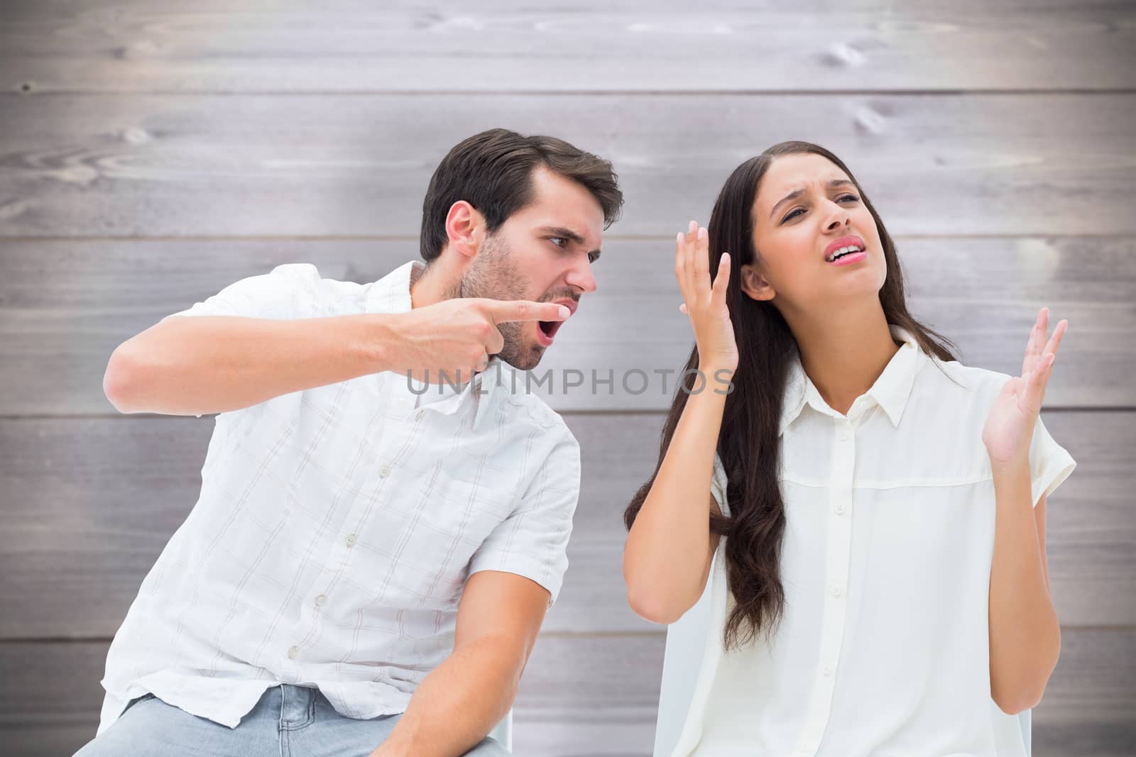 Couple sitting on chairs arguing against wooden planks background