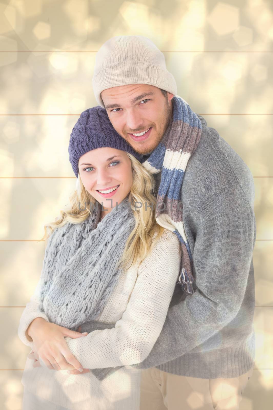 Attractive couple in winter fashion hugging against light glowing dots design pattern