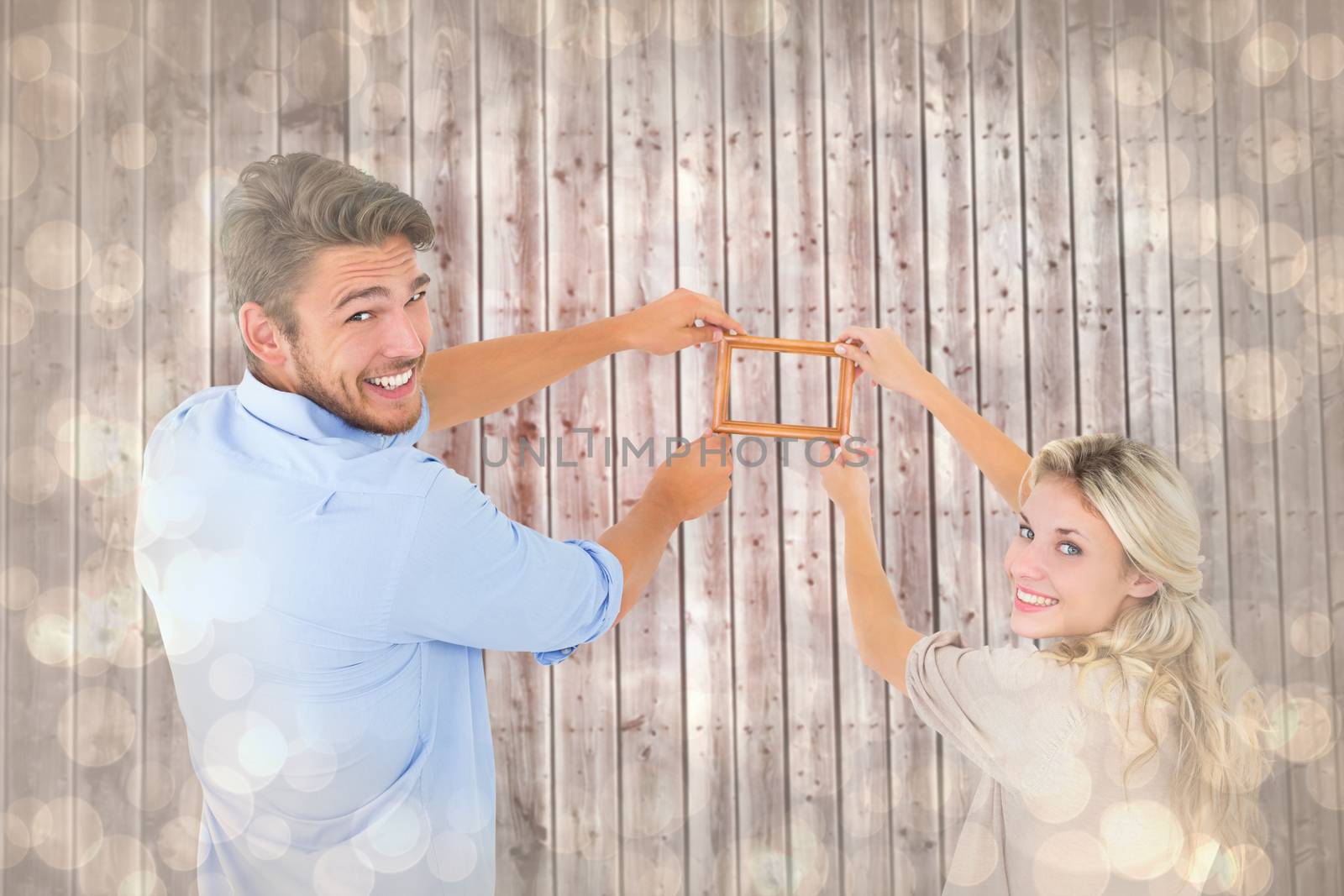 Composite image of attractive young couple hanging a frame by Wavebreakmedia