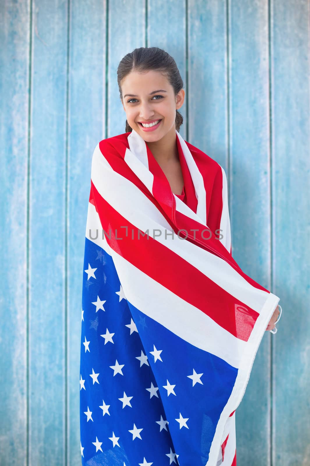Pretty brunette wearing the american flag against wooden planks