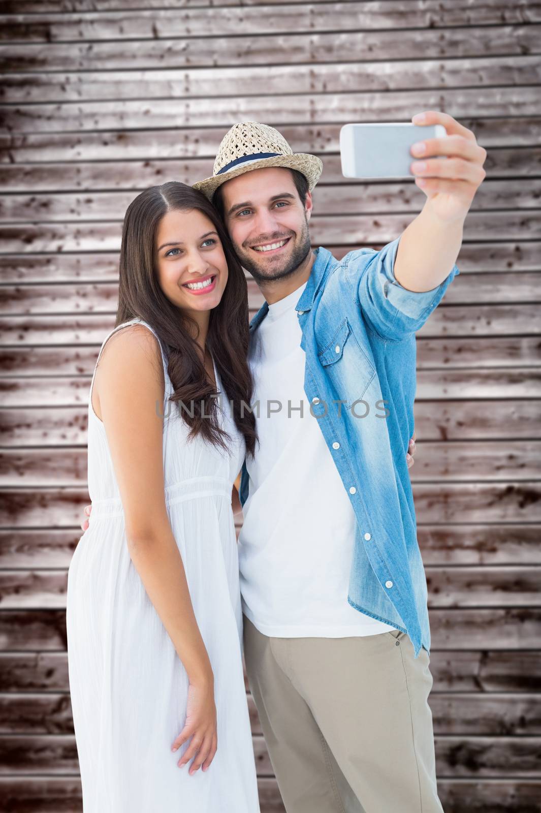 Happy hipster couple taking a selfie against wooden planks