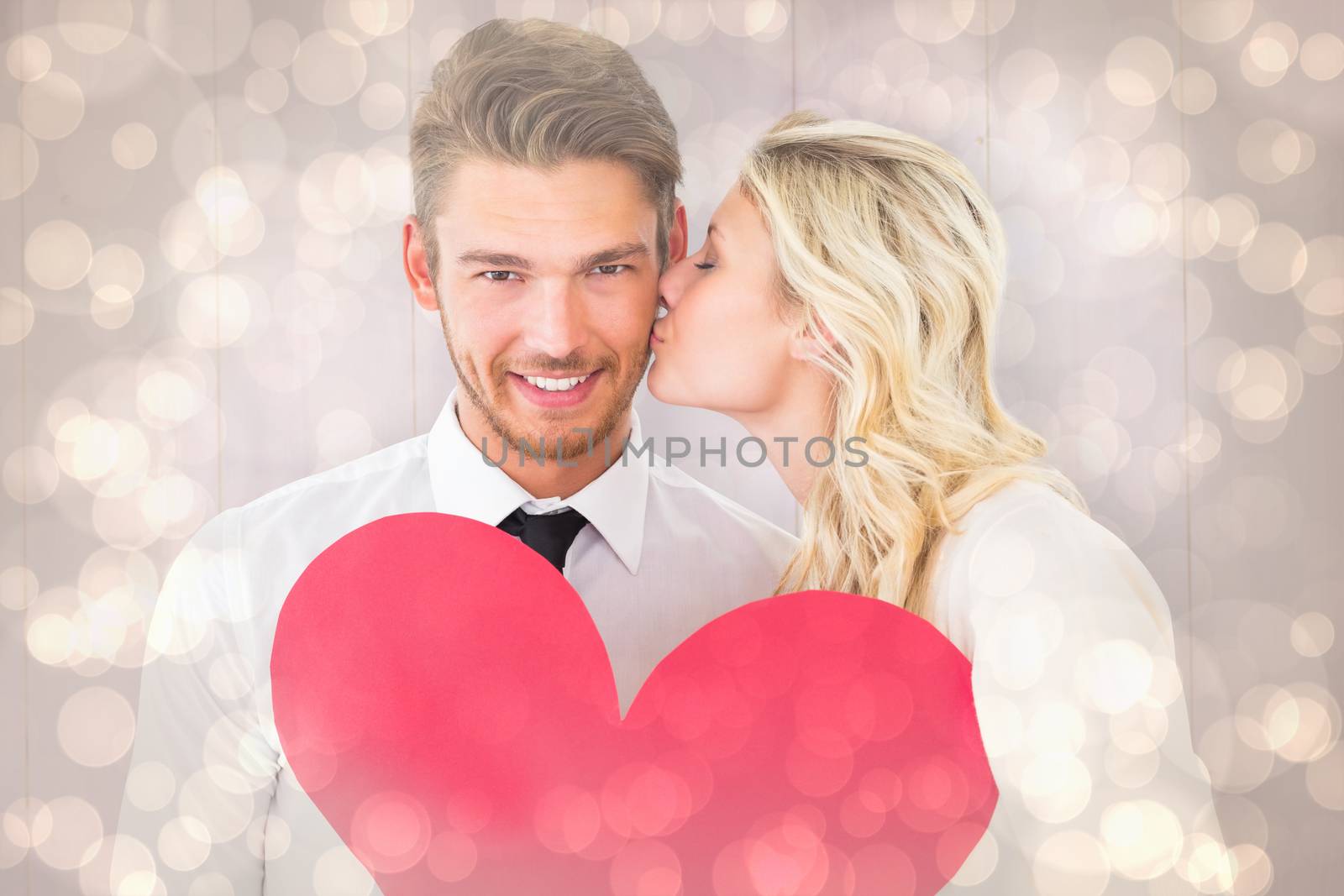 Composite image of attractive young couple holding red heart by Wavebreakmedia