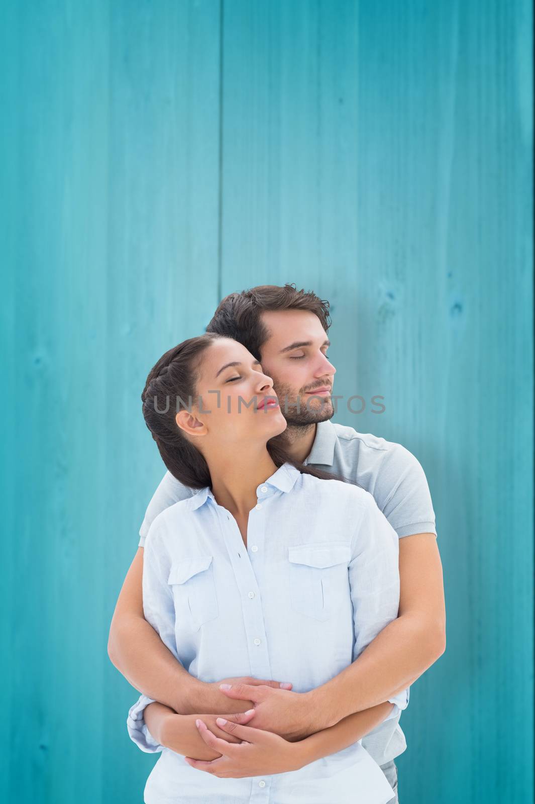 Cute couple embracing with eyes closed against wooden planks background