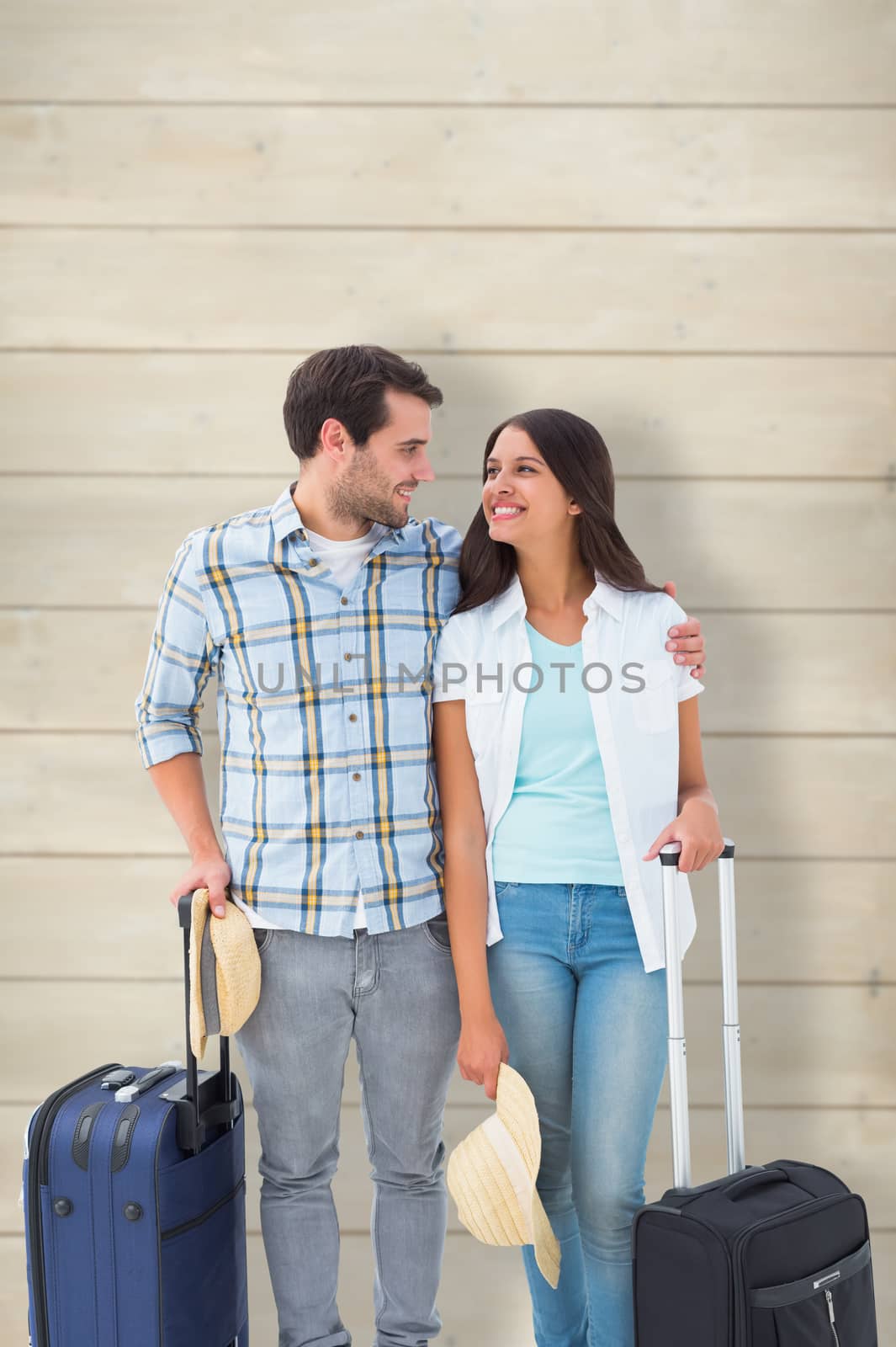 Attractive young couple going on their holidays against wooden planks