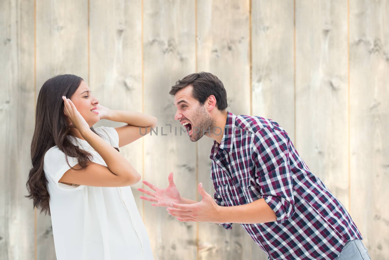 Fearful brunette being overpowered by boyfriend against pale wooden planks