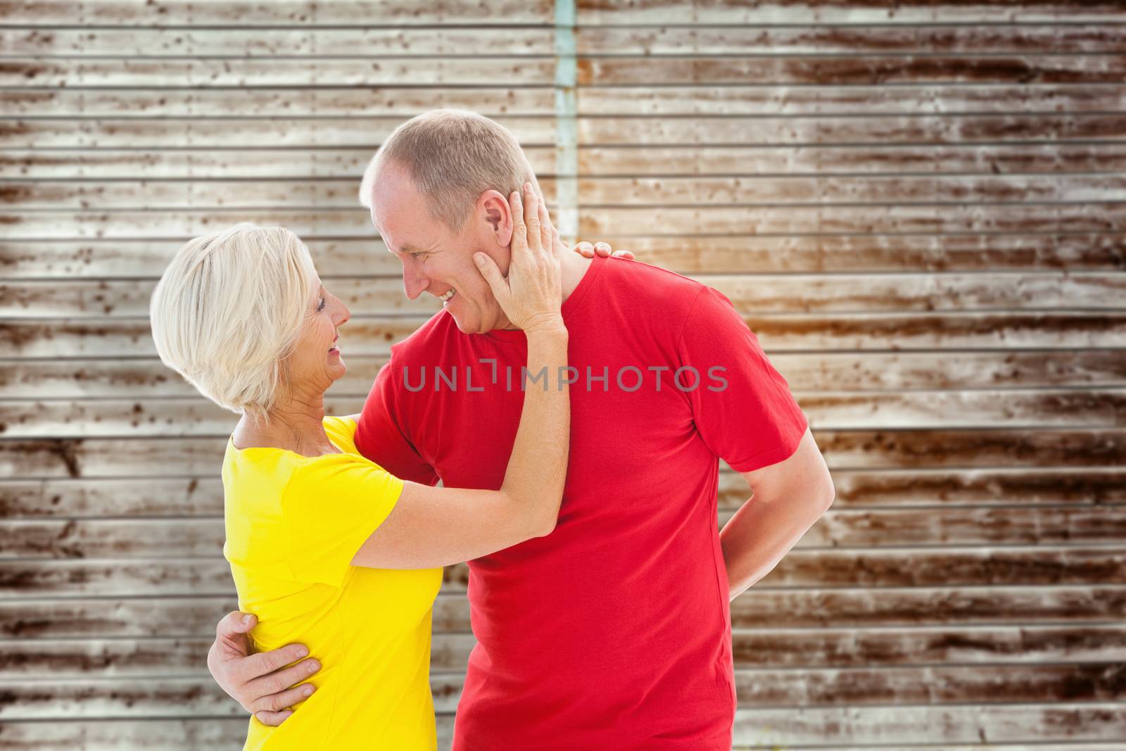 Composite image of happy mature couple hugging and smiling by Wavebreakmedia
