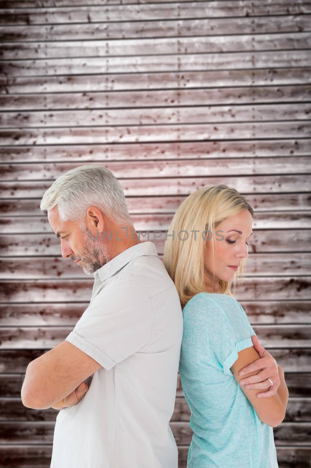 Unhappy couple not speaking to each other  against wooden planks