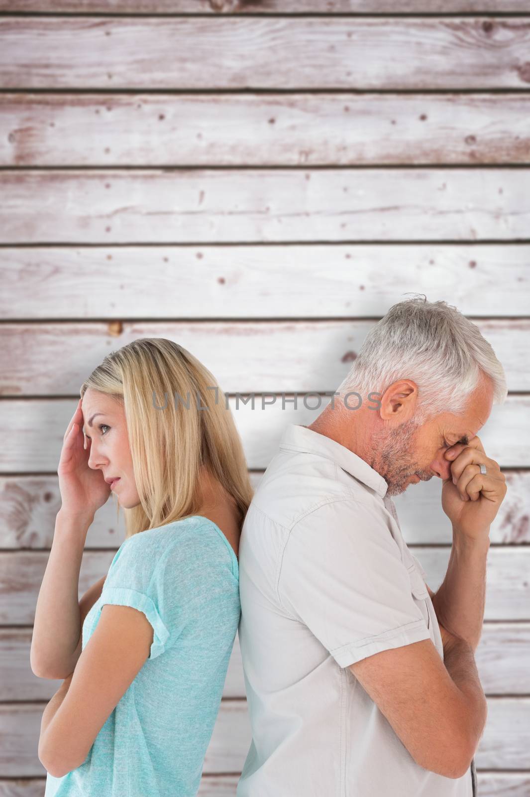 Unhappy couple not speaking to each other  against wooden planks