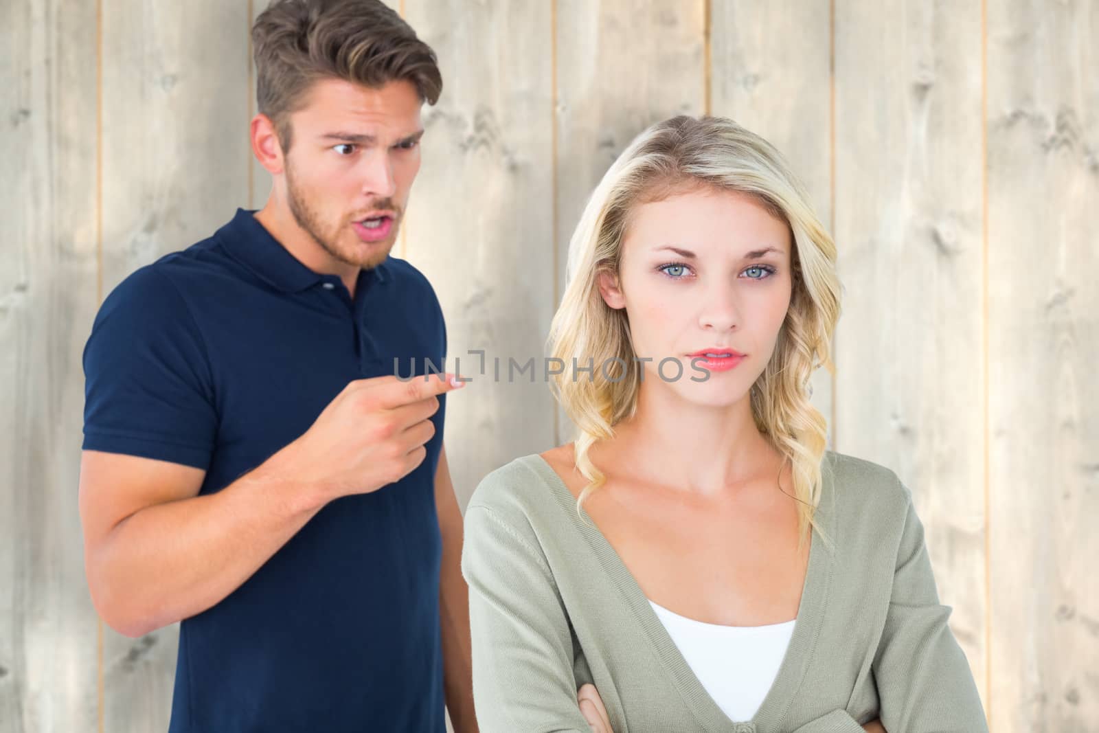 Young couple having an argument against pale wooden planks