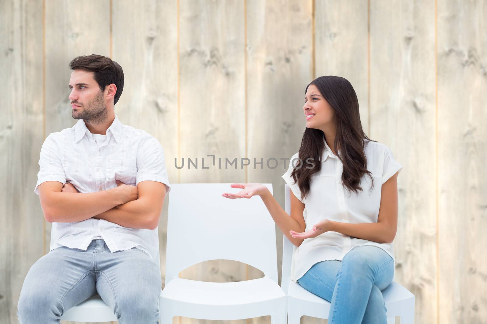 Brunette pleading with angry boyfriend against pale wooden planks