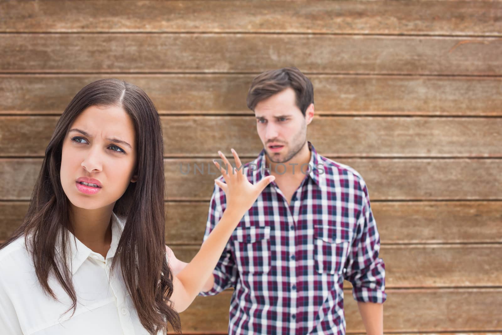 Angry brunette not listening to her boyfriend against wooden planks background