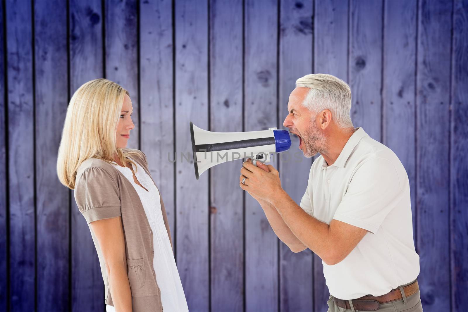 Composite image of angry man shouting at girlfriend through megaphone by Wavebreakmedia