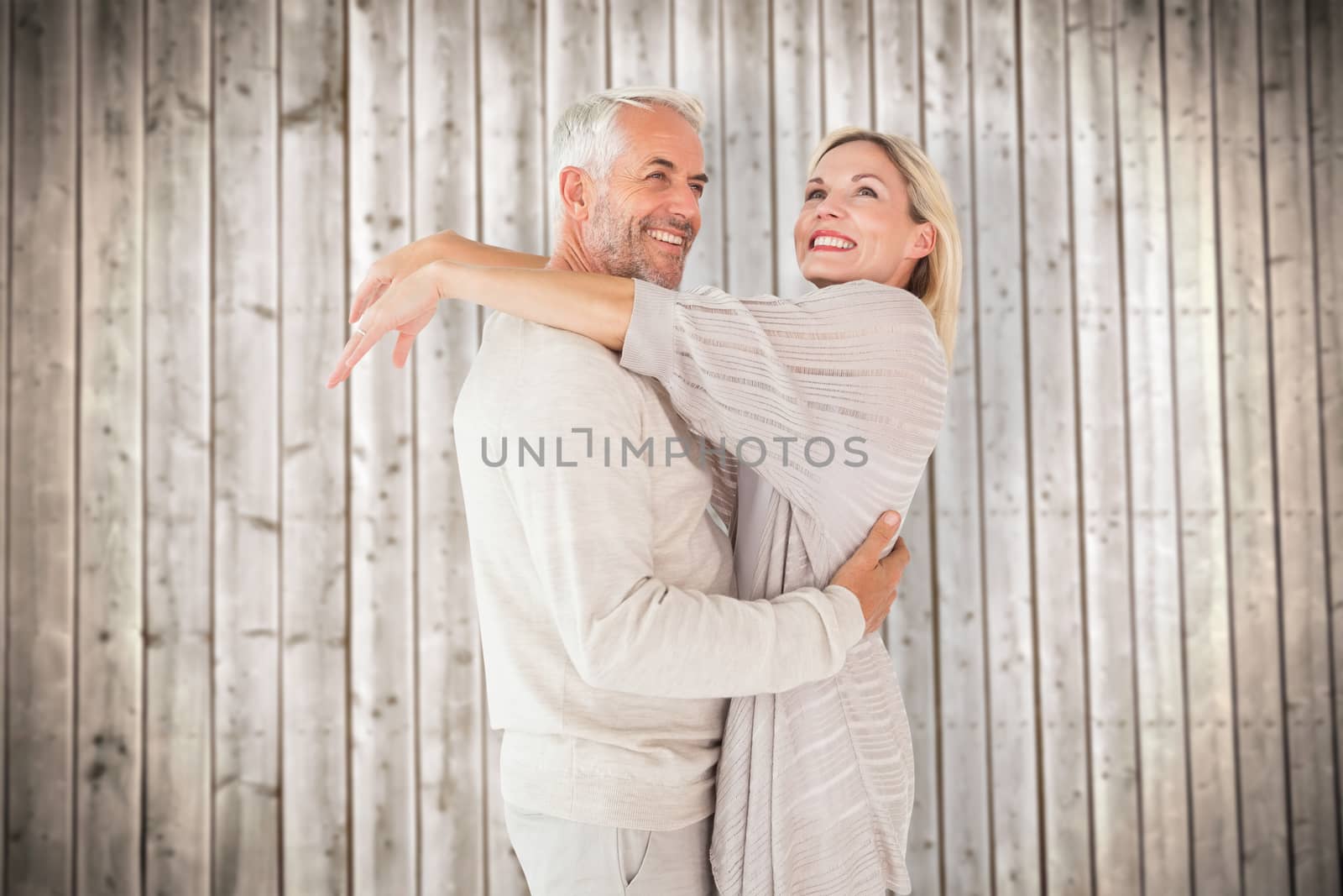 Composite image of happy couple standing and hugging by Wavebreakmedia