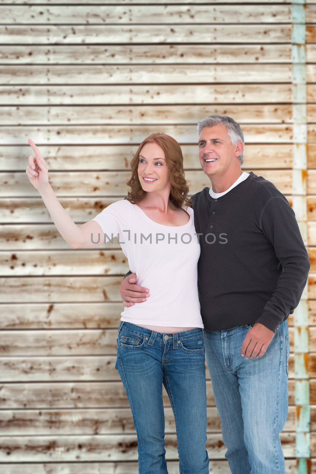 Casual couple walking and pointing against faded pine wooden planks