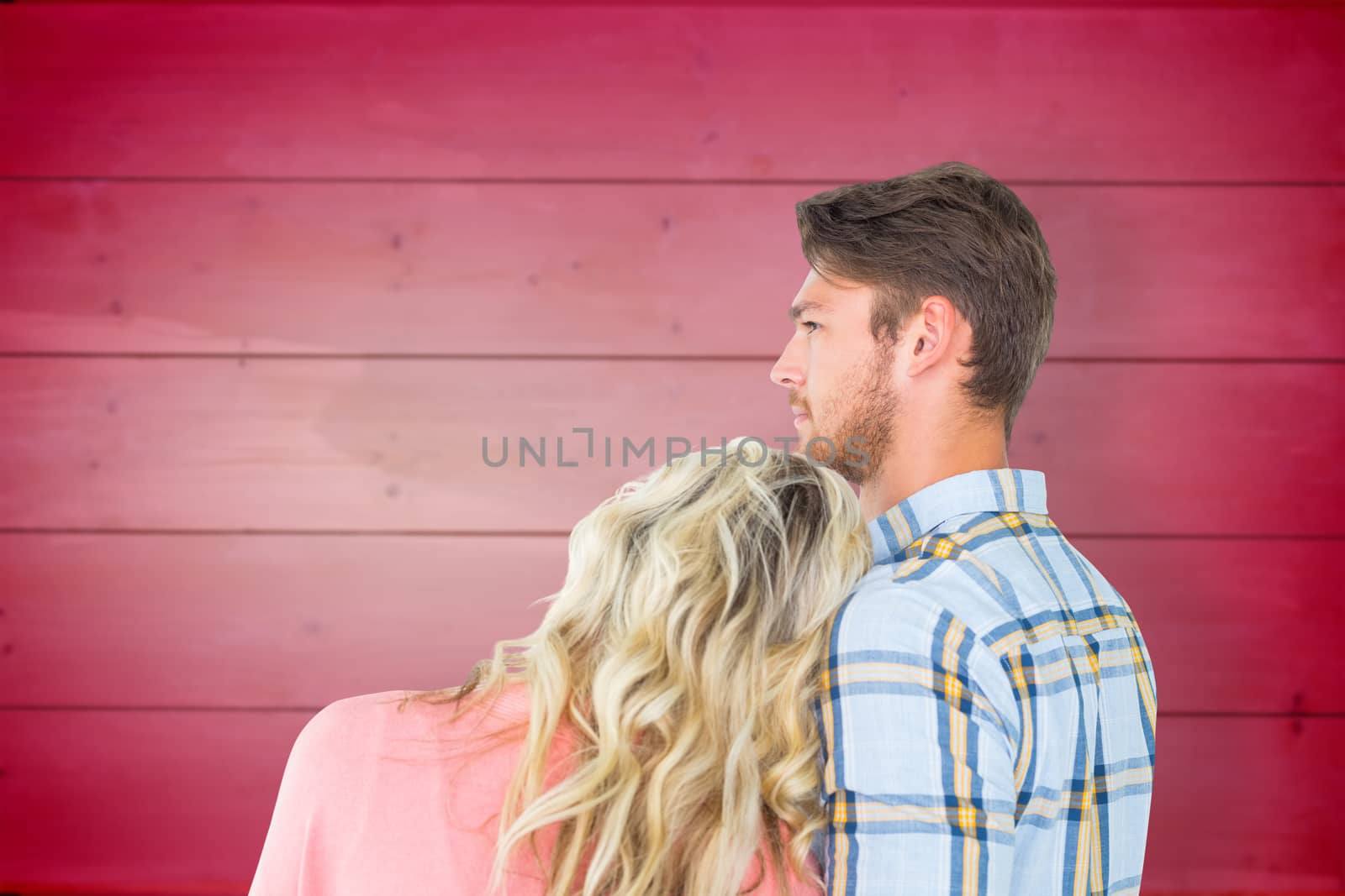 Attractive young couple looking together against wooden planks background