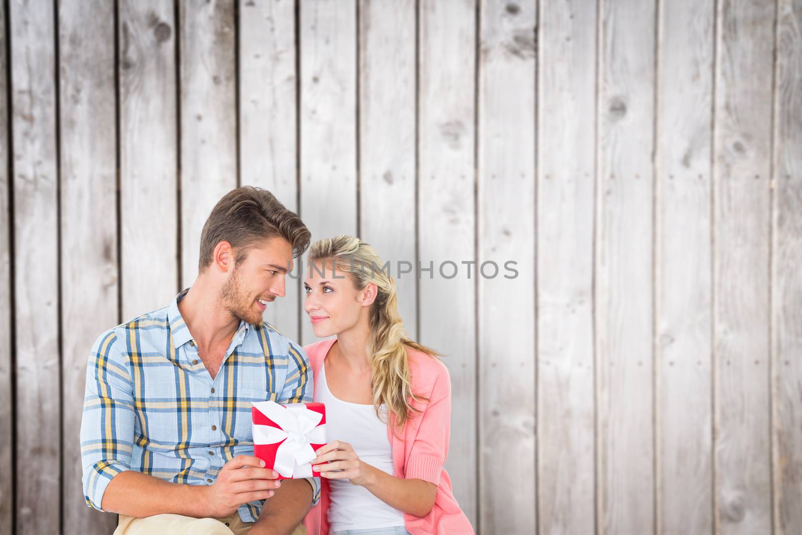 Couple with gift against wooden planks