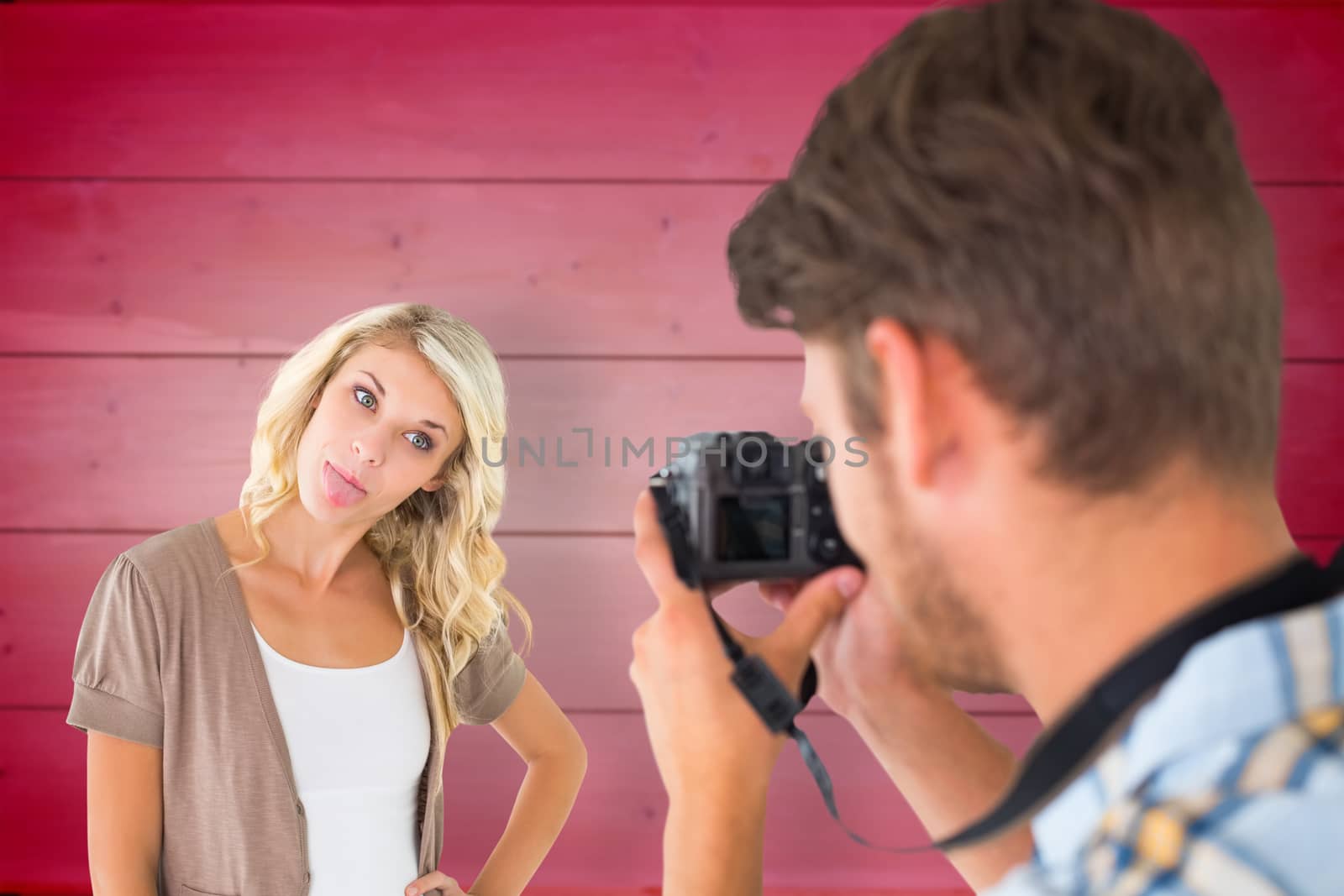 Composite image of man taking photo of his girlfriend sticking her tongue out by Wavebreakmedia