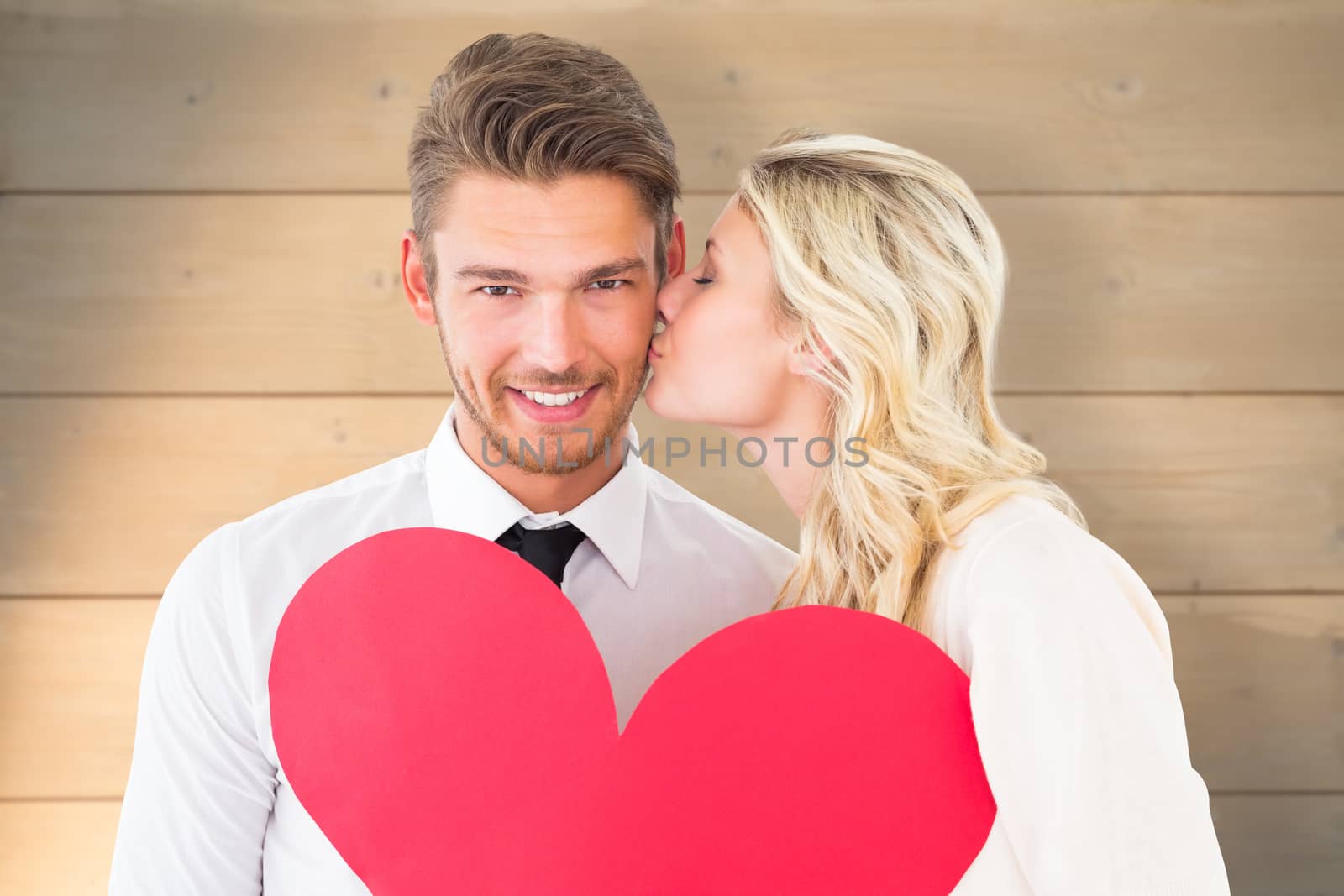 Composite image of attractive young couple holding red heart by Wavebreakmedia