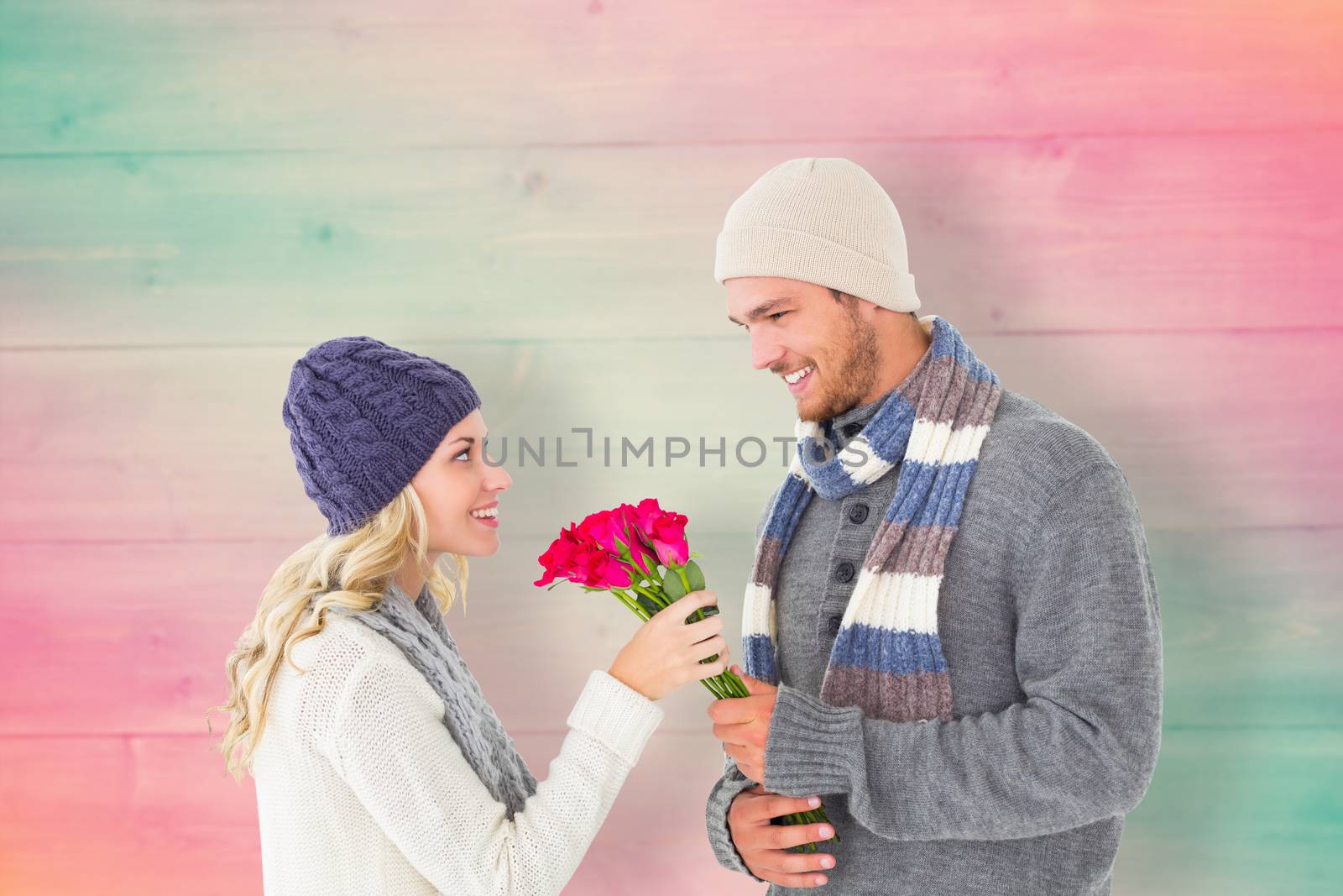 Composite image of attractive man in winter fashion offering roses to girlfriend by Wavebreakmedia