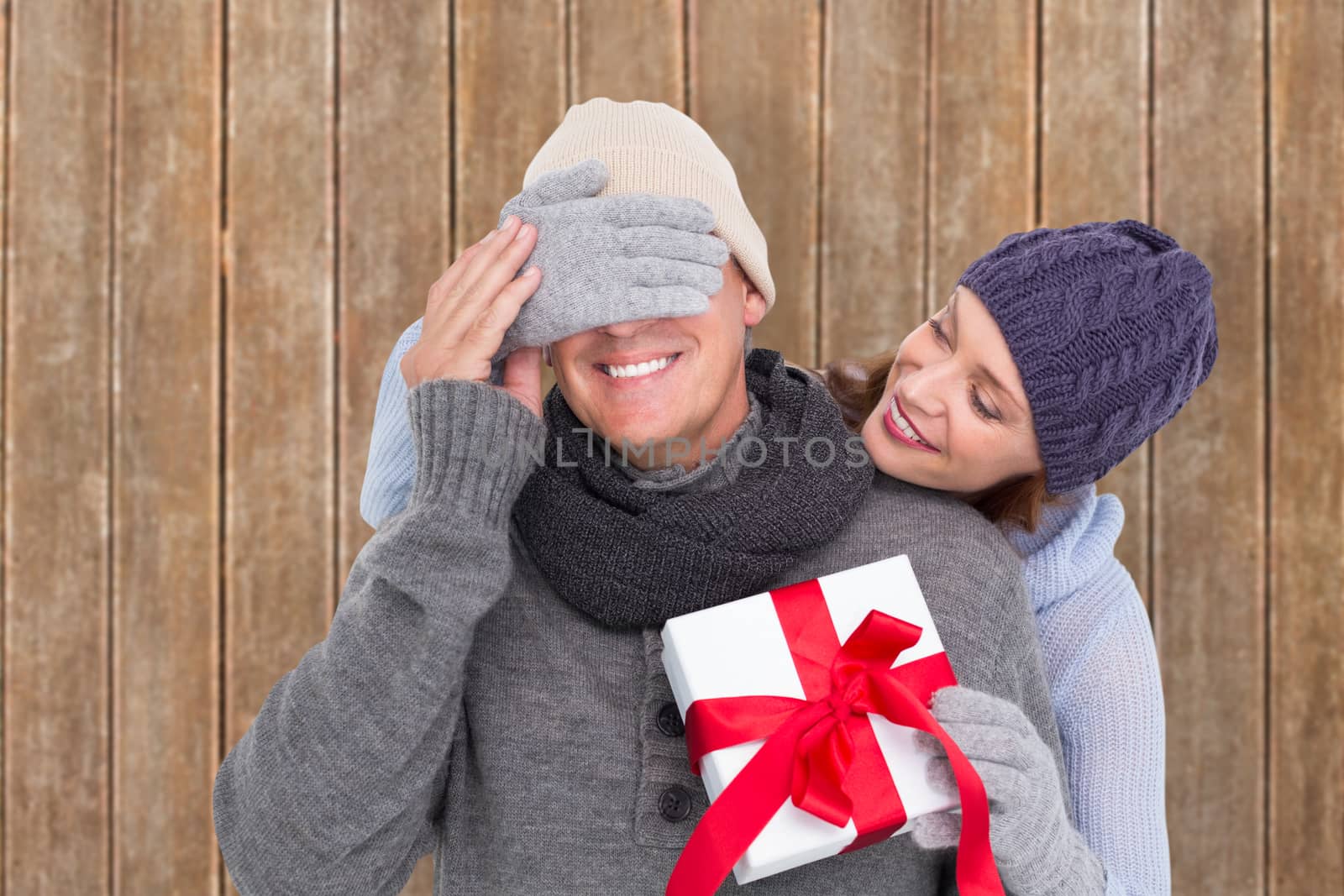 Composite image of woman surprising husband with gift by Wavebreakmedia
