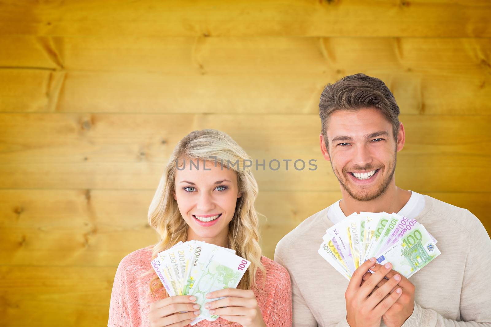 Composite image of attractive couple flashing their cash by Wavebreakmedia